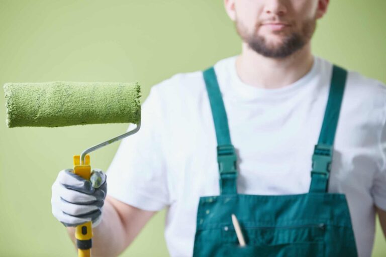 Malerbetrieb CasaColor: Ein Handwerker hält eine grüne Farbrolle in der Hand.